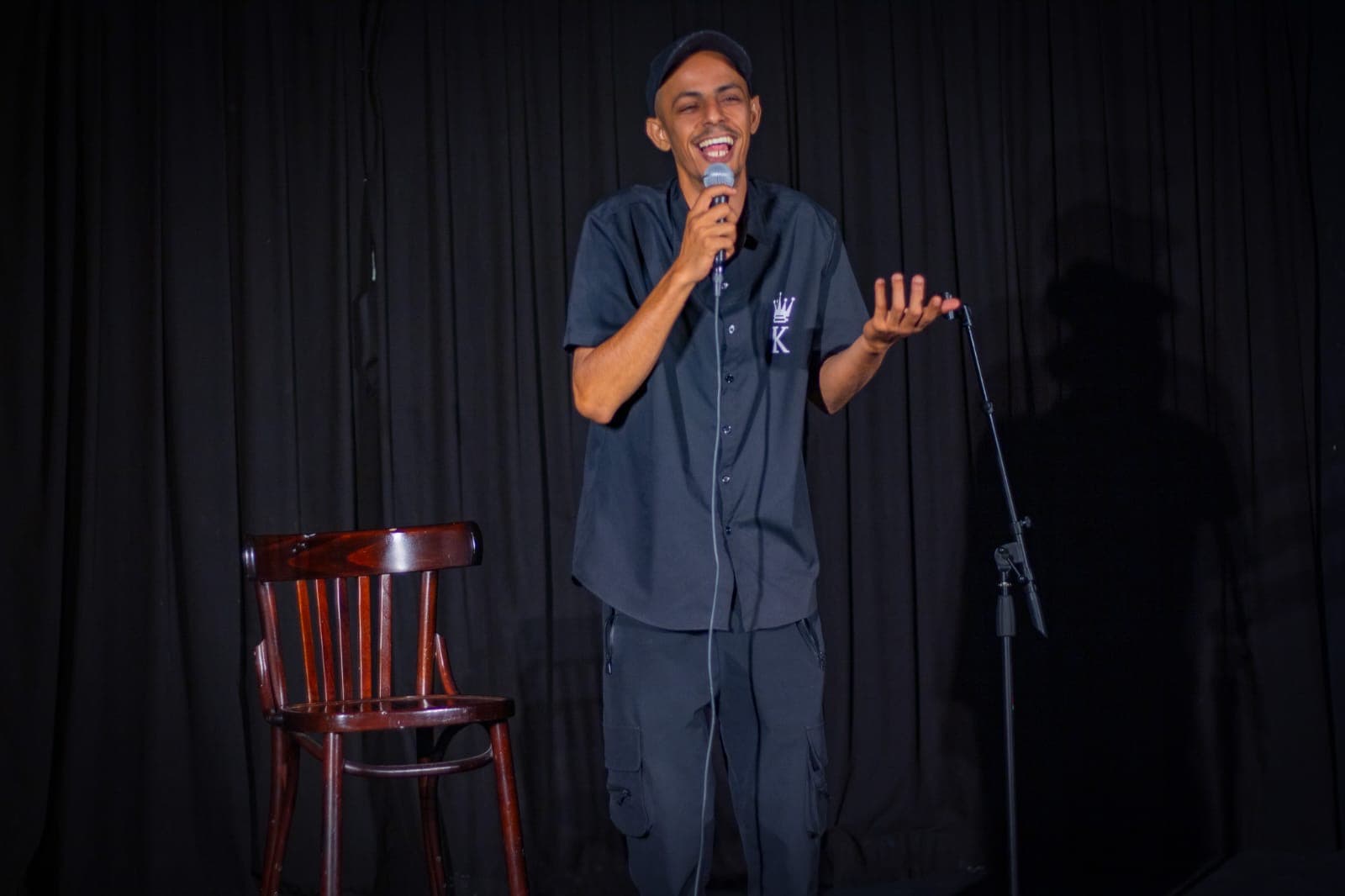 Mohammad Namma performing stand-up comedy on stage in Arabic and Hebrew, entertaining diverse audience